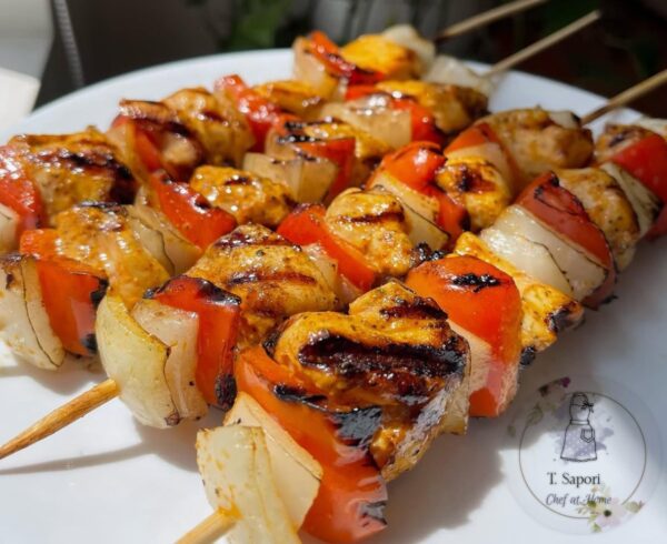Chicken breast skewers topped with caramelized onions.
